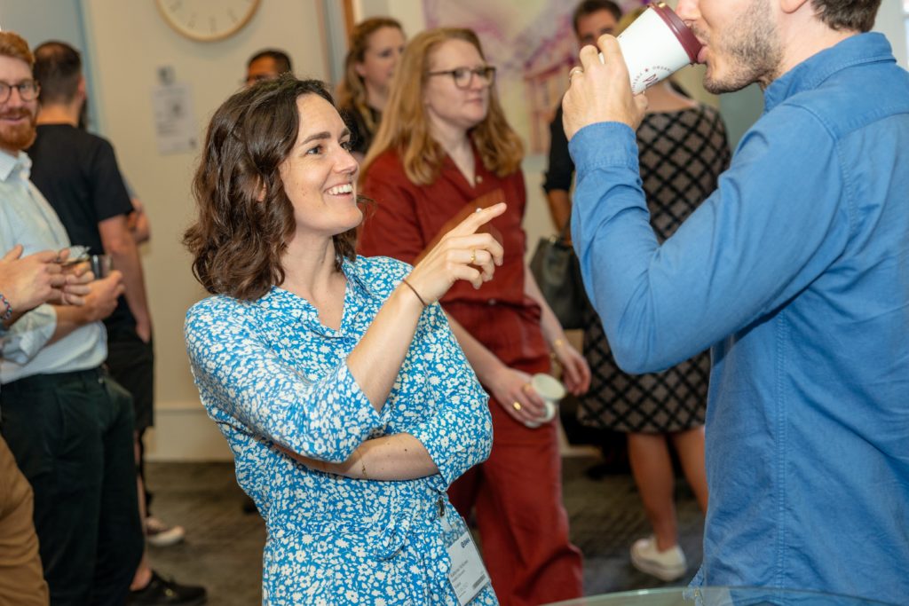 Image of a Mindful Education employee smiling and interacting with another colleague at the annual Mindful Education Summer Conference.