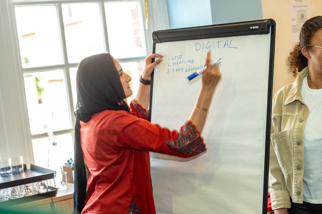 A Mindful Education Employee writing notes on a paper board as part of a team building exercise at the annual company Summer Conference.