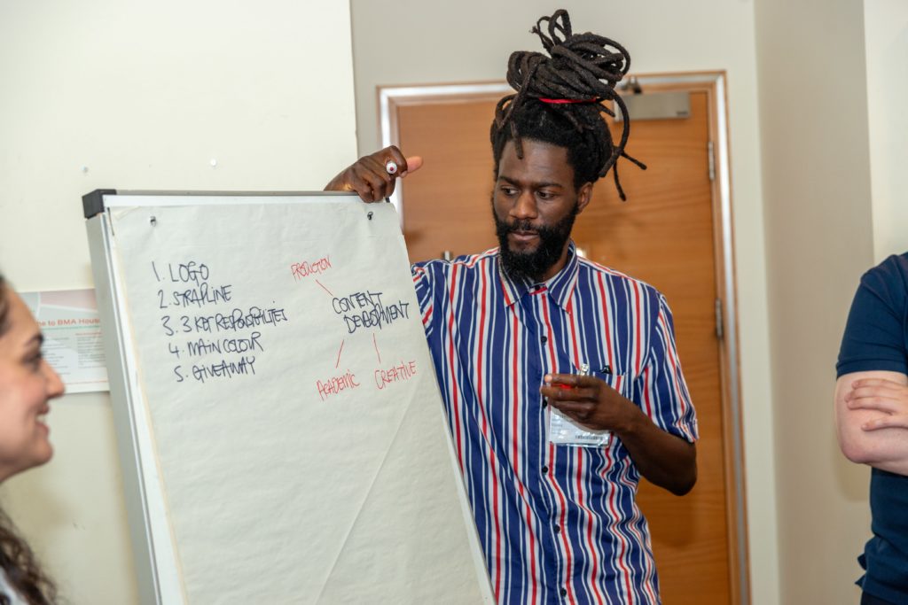 A Mindful Education Employee looking at a paper board with various notes as part of a team building exercise at the annual company Summer Conference.