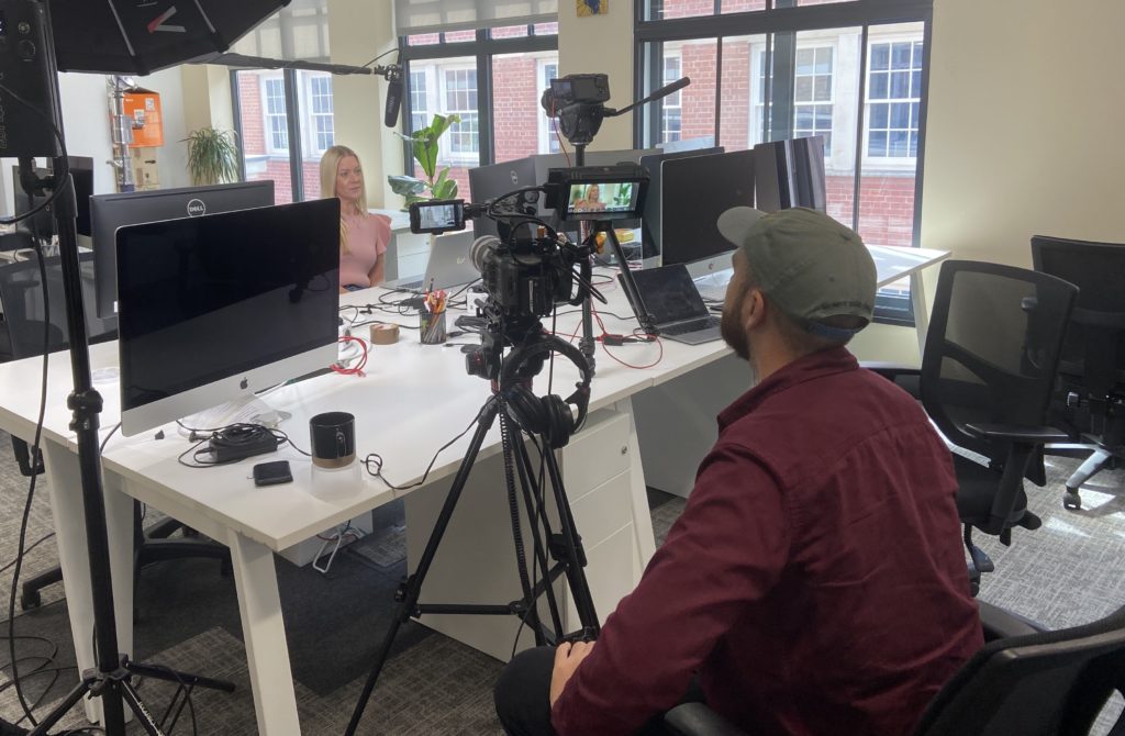 A Mindful Education employee being filmed in the office by another Mindful Education employee.