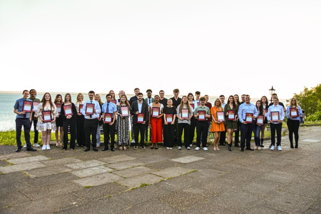 A photo of many learners holding awards recognising their excellence and achievements during their courses and apprenticeships.