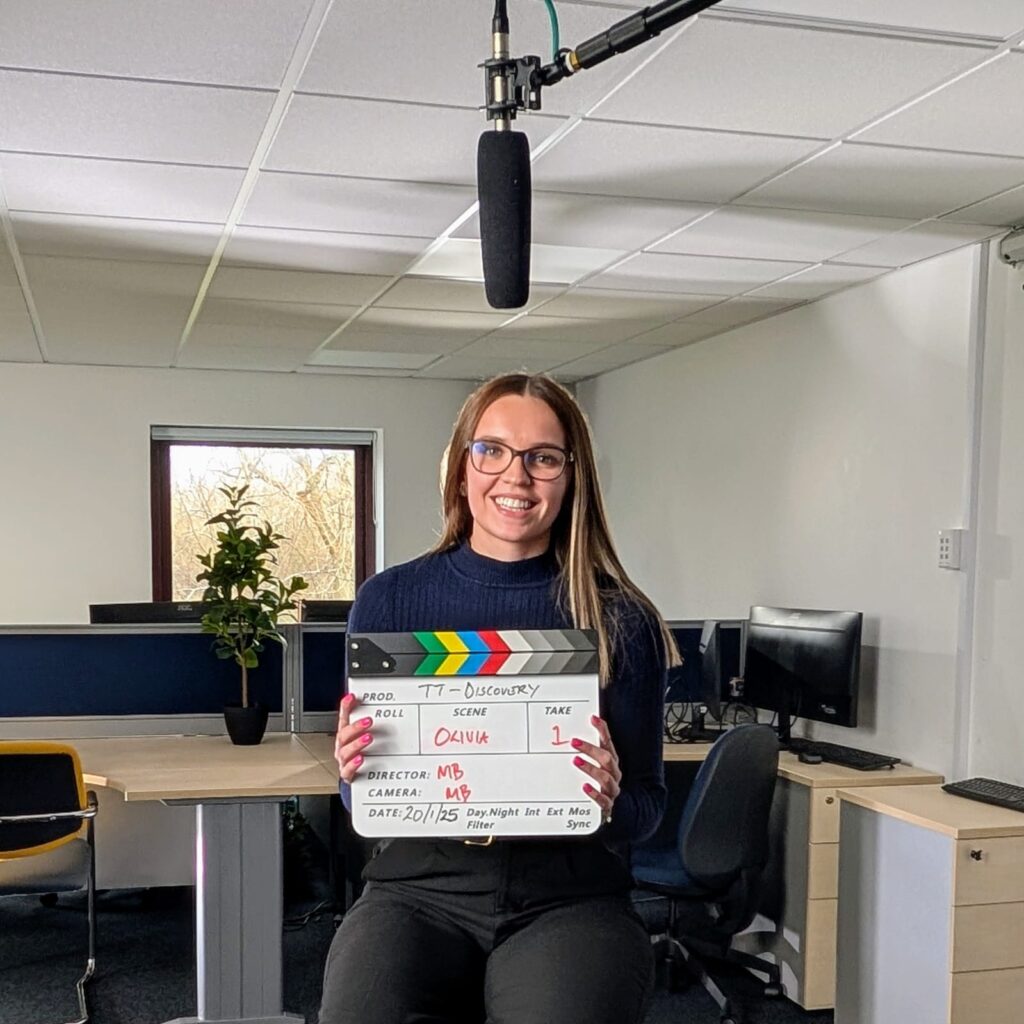 Image of a finance apprentice who has studied a professional and flexible Mindful Education apprenticeship, holding a clapperboard.