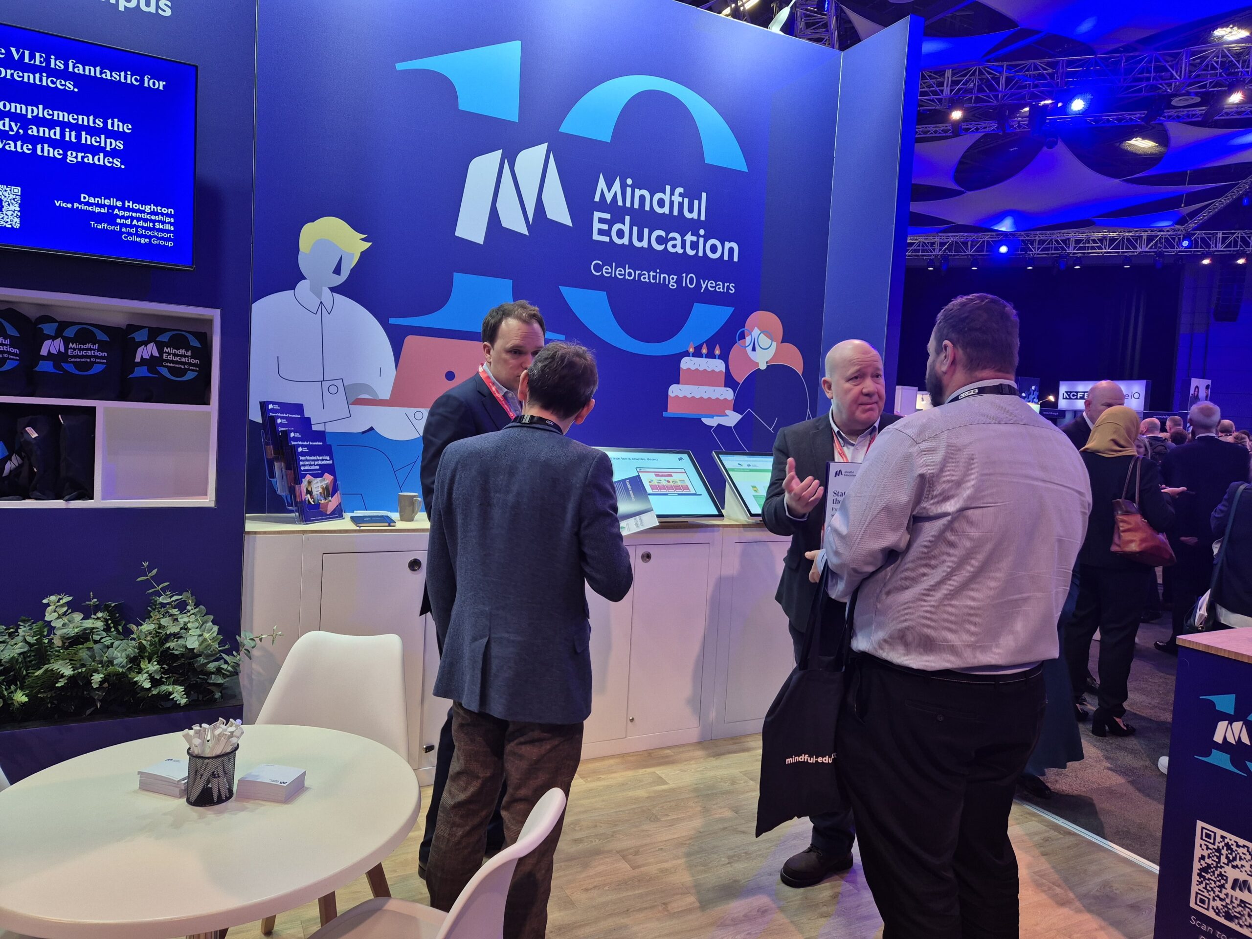 An image showing, Mindful Education team members speaking with professionals at an industry event.