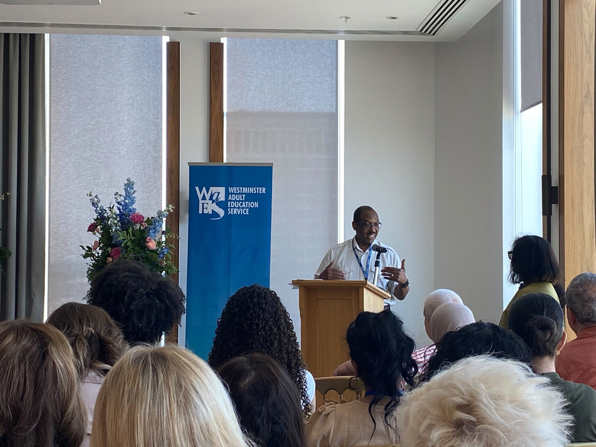 An image showing a college award ceremony taking place, with a tutor presenting awards